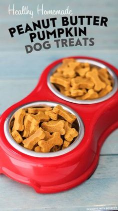 two red bowls filled with peanut butter and dog treats on top of a wooden table