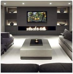 a large living room with couches and a flat screen tv on the wall,