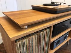 an old record player sitting on top of a wooden cabinet with vinyl records in it