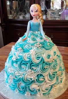 a blue and white cake that looks like a princess in a dress with flowers on it