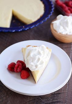 a slice of cheesecake on a plate with raspberries