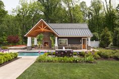 a small house with a pool and covered patio in the middle of some grass area