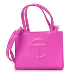 This is an authentic TELFAR Vegan Leather Small Shopping Bag in Azalea. This mini tote is constructed of faux leather in pink with the iconic raised Telfar logo at the front. The shoulder bag has thin pink handles and a long crossbody strap. The bag opens to a matching fabric interior. Telfar Logo, Pink Handles, Green Highlights, Pool Bags, Orange Bag, Mini Tote, White Bag, Crossbody Strap, Vegan Leather