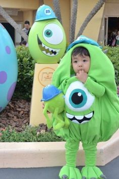 a little boy dressed up as monsters standing in front of some fake eggs