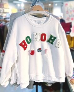 a white shirt with the word ho hoo on it hanging in a clothing store