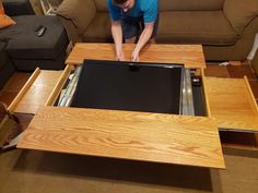 a man working on an open drawer in a living room