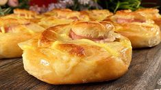 ham and cheese puffs on a wooden table with flowers in the backgroud