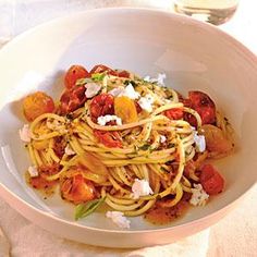 a white bowl filled with pasta and tomatoes