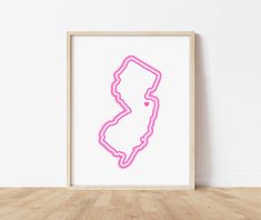 a neon pink framed map of the state of michigan on a white wall in an empty room