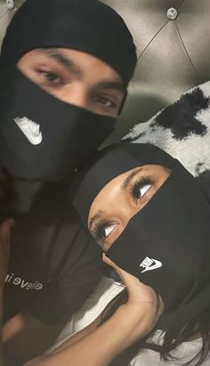 two people wearing black face coverings on their heads and one person has her eyes closed