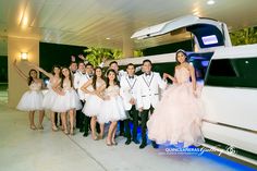 a group of people standing next to each other in front of a limo