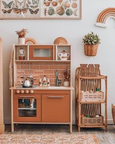 a kitchen with an orange stove top oven next to a wooden shelf filled with pots and pans