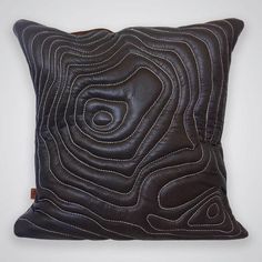 a black leather pillow with an abstract design