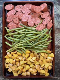 sausages, green beans and potatoes in a roasting pan