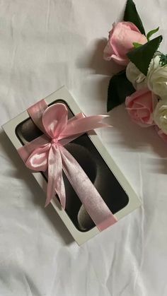 two pairs of shoes in a gift box with pink ribbon and flowers on the side