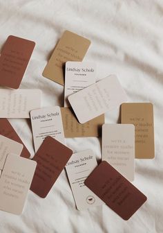 there are many business cards laid out on the bed sheet, all in different colors