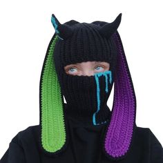 a person wearing a knitted mask with horns on it's head and purple hair