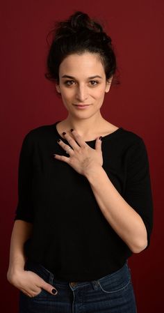 a woman posing with her hand on her chest in front of a red background,