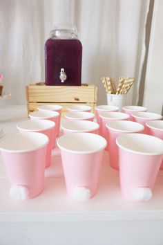 pink cups are lined up on a table