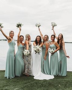 a group of women standing next to each other holding bouquets