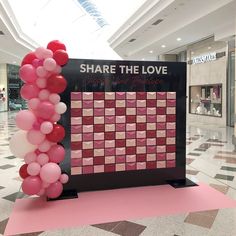 there is a sign that says share the love and balloons in front of it on display