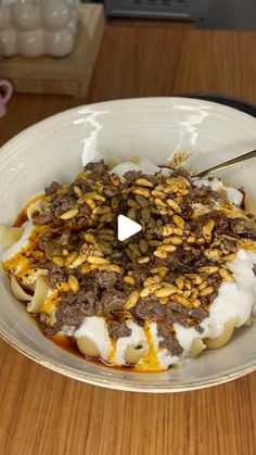 a bowl filled with food on top of a wooden table