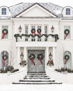 a large white house with wreaths on the front