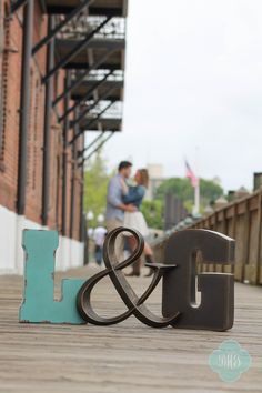 a couple sitting on a bench next to the letter l and i in front of a building