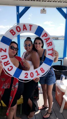 three women pose for a photo while holding a life preserver