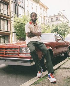 a man sitting on the hood of a car