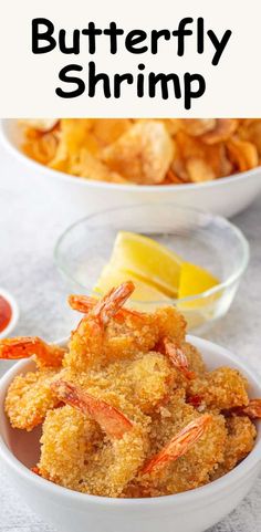 two bowls filled with fried shrimp next to potato chips and ketchup on the side