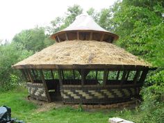 an old wooden structure with grass covering it