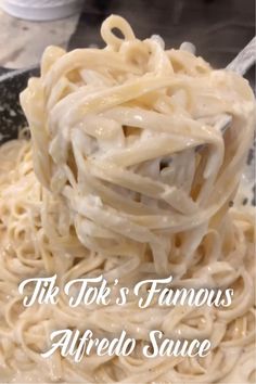 a spoon full of noodles with the words tiki's famous alfredo sauce