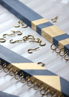 several pairs of gold and blue scissors are on the white tablecloth with other tools