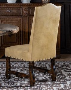 a dining room chair with nailing on the back and seat, sitting in front of a table