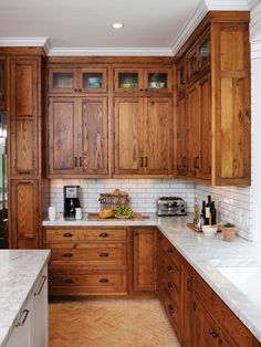 a kitchen with wooden cabinets and marble counter tops