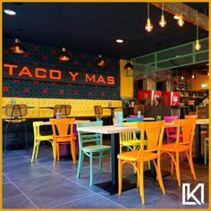 the inside of a restaurant with colorful tables and chairs