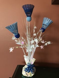 a vase filled with blue and white stars on top of a table next to a wall