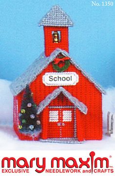 a red school building with a christmas tree on the roof and snow in front of it