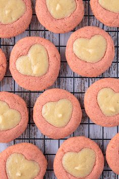 heart shaped cookies on a cooling rack with yellow icing in the shape of a heart