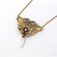 Gorgeous antique circa 1900s era Art Nouveau 10k yellow gold lavalier necklace! This stunning pendant has gorgeous swirling designs and a four leaf clover motif, accented with seed pearls. There is a decorative baroque pearl dangling from the bottom of the piece. A fantastic piece of fine antique jewelry, featuring June's birthstone!  ERA - Circa 1900s - Art Nouveau  METAL / MATERIAL - 10k yellow gold pendant and chain, seed pearls MARKINGS / HISTORY - Back of pendant is stamped 10k CONDITION - Good antique condition. Yellow gold metal has been professionally polished & cleaned. Age appropriate patina & wear remains. Amazing antique necklace!  SIZE / MEASUREMENTS - Length: 14 1/2 inches, Pendant length: 1.5 inches, Total Weight: 4.28 grams PRESENTATION - Listing includes a complimentary MJ Ornate Historical Design Necklaces For Formal Occasions, Ornate Historical Design Necklace For Formal Occasions, Elegant Pendant Necklaces With Historical Design, Heirloom Antique Gold Pendant Necklace, Elegant Historical Pendant Necklaces, Elegant Filigree Necklace For Vintage Events, Antique Gold Evening Jewelry, Antique Gold Jewelry For Evening, Victorian Pendant Necklace For Anniversary