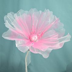 a large pink flower with water droplets on it's petals, in front of a blue background