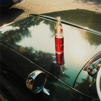 an old car with a bottle on the hood