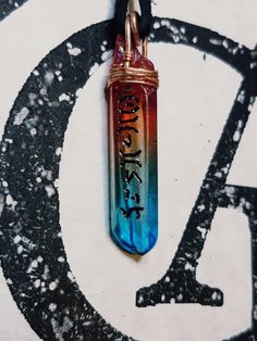 a glass pendant with writing on it sitting on top of a black and white background