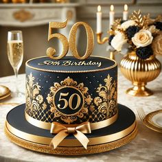 a black and gold 50th birthday cake on a table with flowers, candles and wine glasses