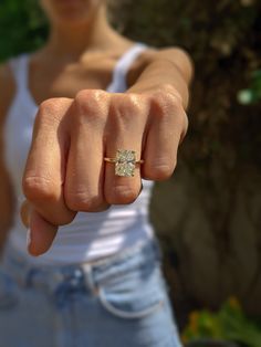 a woman is pointing her finger at the camera with an engagement ring on her finger