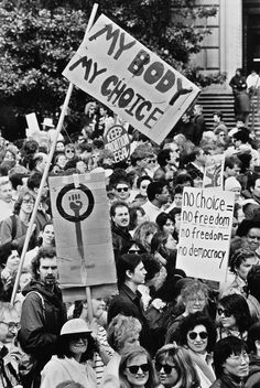 a large group of people holding signs in the street