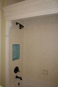 a bathroom with a tub, shower head and hand held faucet in it