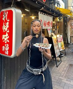 a woman holding a plate of food in front of a store