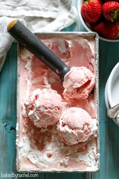 an ice cream sundae with strawberries on the table